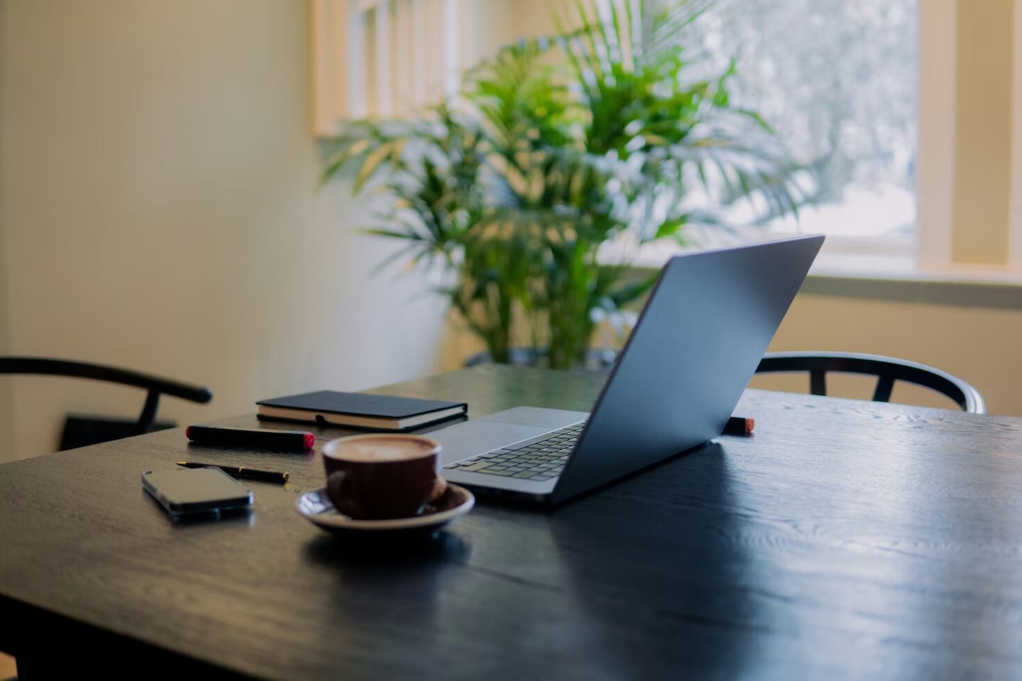 Laptop on a wooden table, representing digital comfort and at‑home leisure activities.